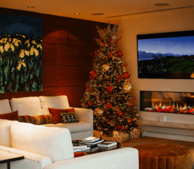 Cosy hotel lounge with a festive Christmas tree, modern fireplace, and plush seating for a relaxing guest experience.