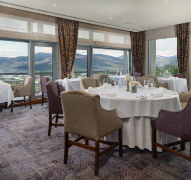 Elegant dining room with mountain views, showcasing fine dining setup, large windows, natural light, and luxurious decor.