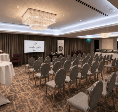 Luxurious hotel conference room with elegant chandeliers, plush seating, and versatile meeting space for business or events.