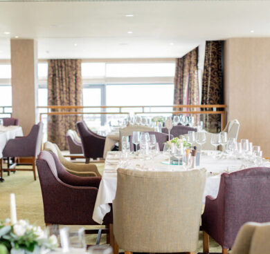 Elegant hotel dining room with sea views, set for a luxurious dining experience.