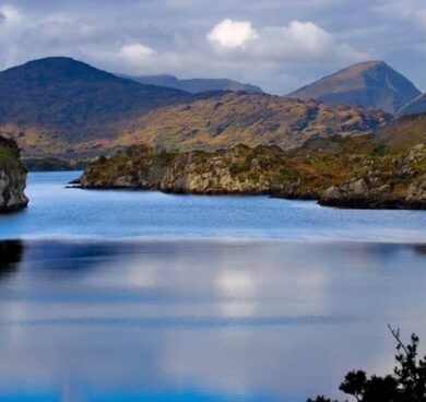 Scenic lake view with surrounding hills, ideal for relaxation, serene getaway, nature retreat, lush landscapes.