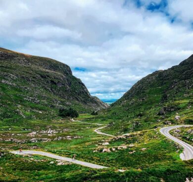 Scenic valley view with winding roads, lush greenery, and blue sky, perfect for a tranquil getaway near our hotel.