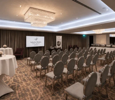Elegant hotel conference room with plush chairs, modern chandeliers, and a welcoming atmosphere for events.